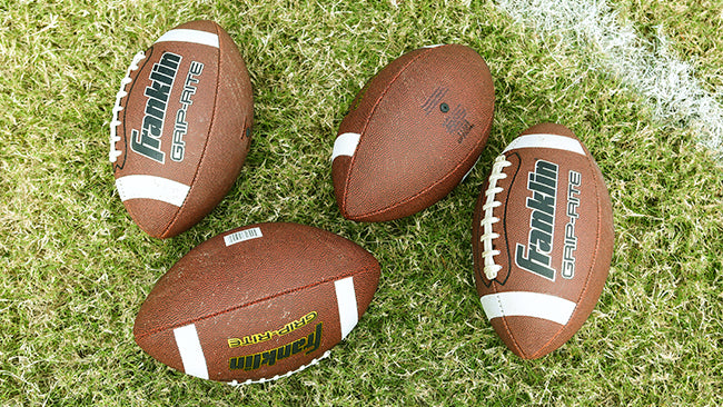 Franklin footballs on a grassy football field.