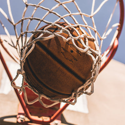 A basketball going into a hoop.