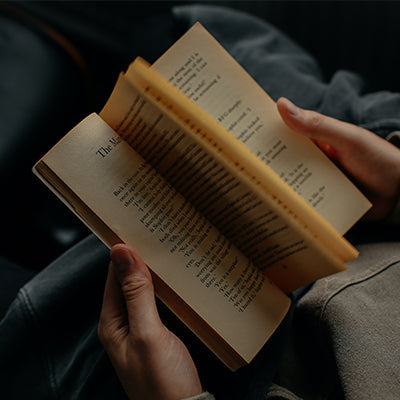 An open book being read by a person.