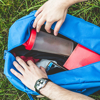 an equipment bag being opened with a sports bottle.